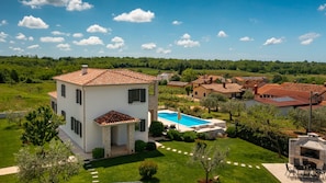 A villa with a swimming pool, surrounded by lush greenery and a clear sky. - Villa Marika by Villas Guide (Vižinada)