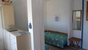 A bedroom with a bed, a small table, a desk with a lamp, and a mirror. - Vera Cruz A4 (Lido di Jesolo)