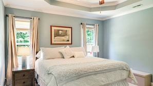 Ein Schlafzimmer mit Bett, Nachttisch und einem gerahmten Bild an der Wand.