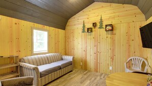 Una habitación acogedora con un sofá, una silla, una mesita y una ventana.