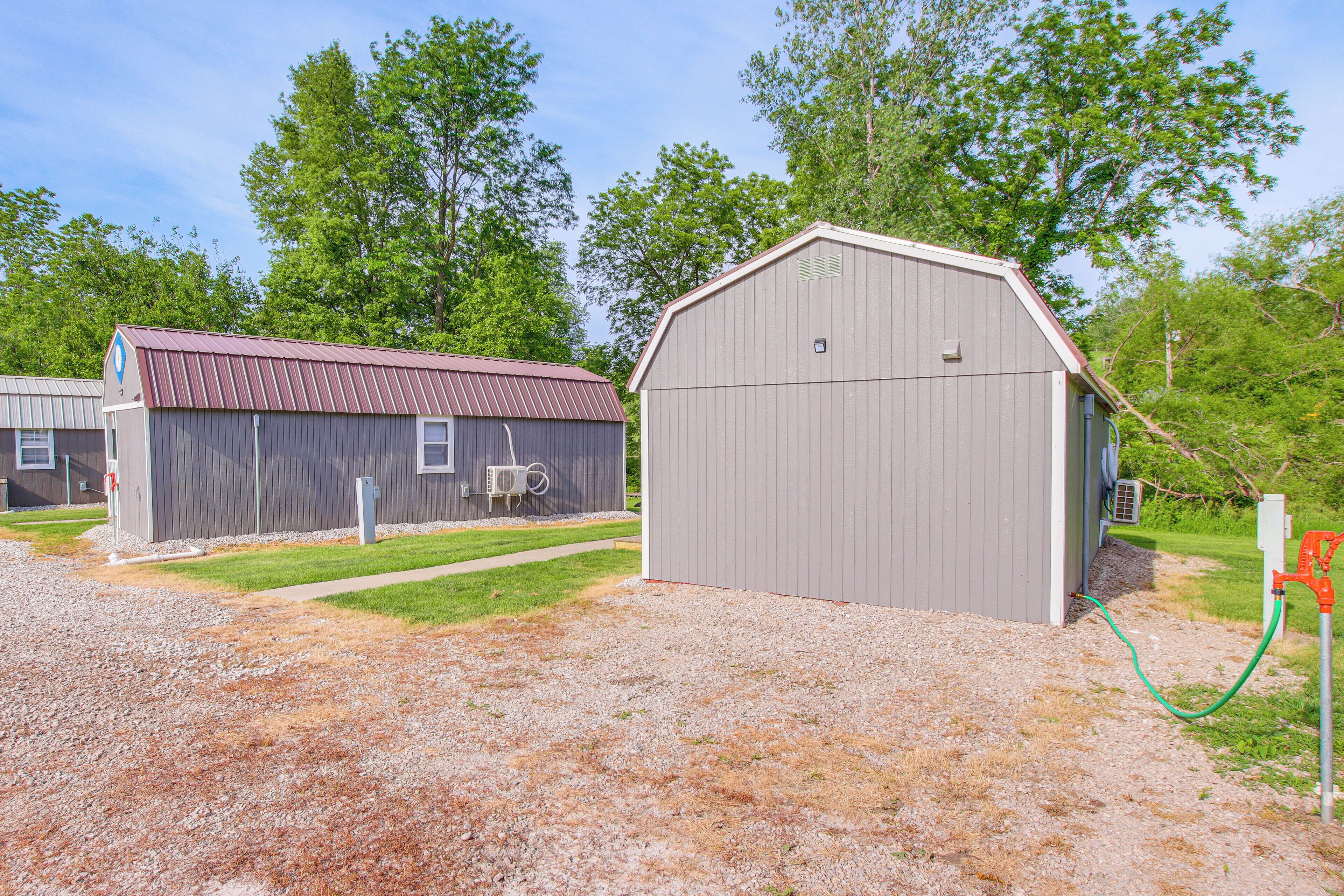A building with a metal roof and a gravel driveway.