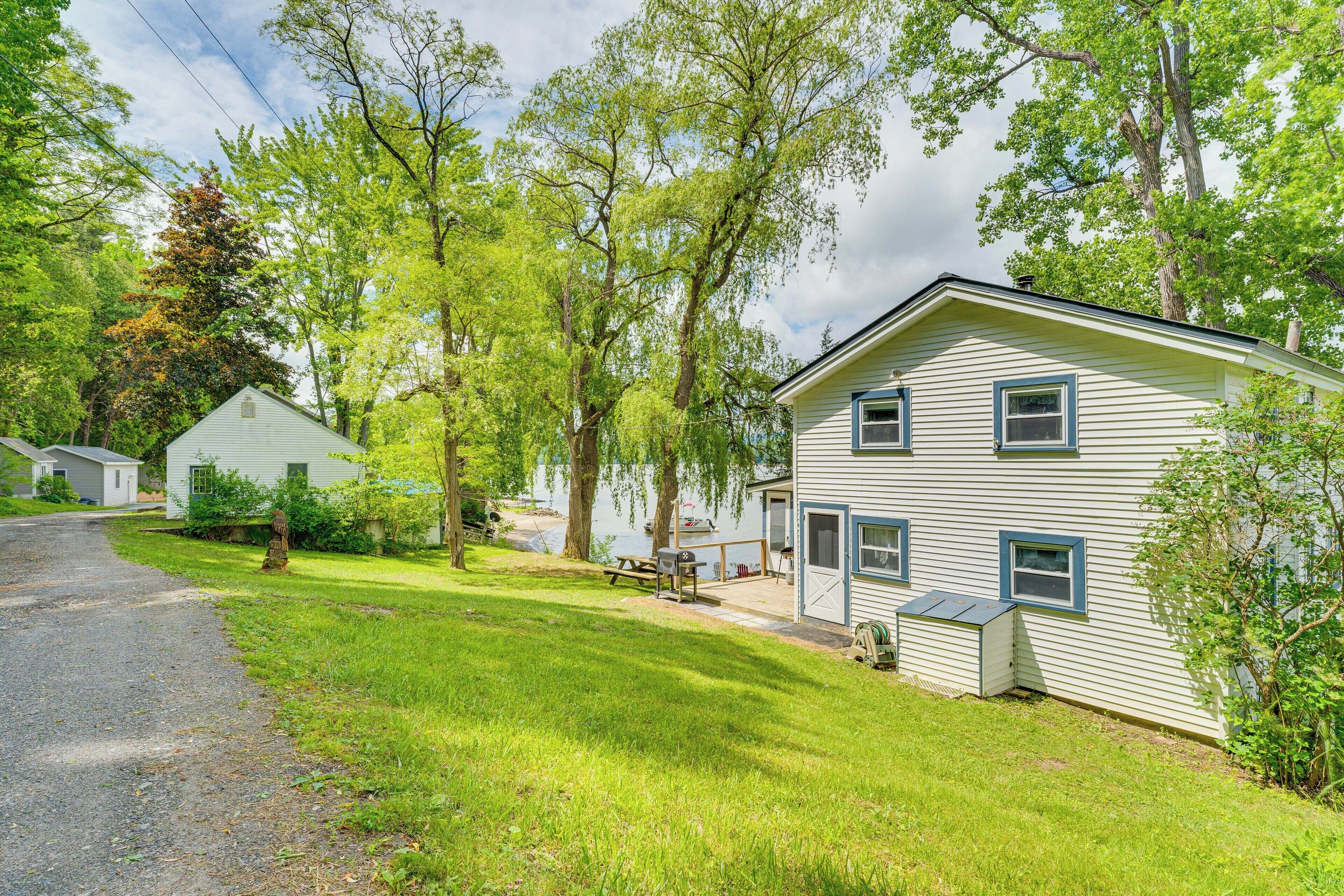 A two-story house with a front porch, a small deck, and a picnic table.
