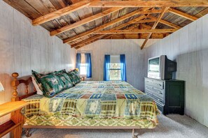 A bedroom with a wooden ceiling, a bed with a quilt, a dresser, and a television. - Waterfront Home on Lake Champlain w/ Dock & Kayaks (Fair Haven)
