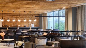 A modern interior with wooden ceiling, dining area, sofas, and large windows. - Hyatus Luxury Residences Stamford (Stamford)