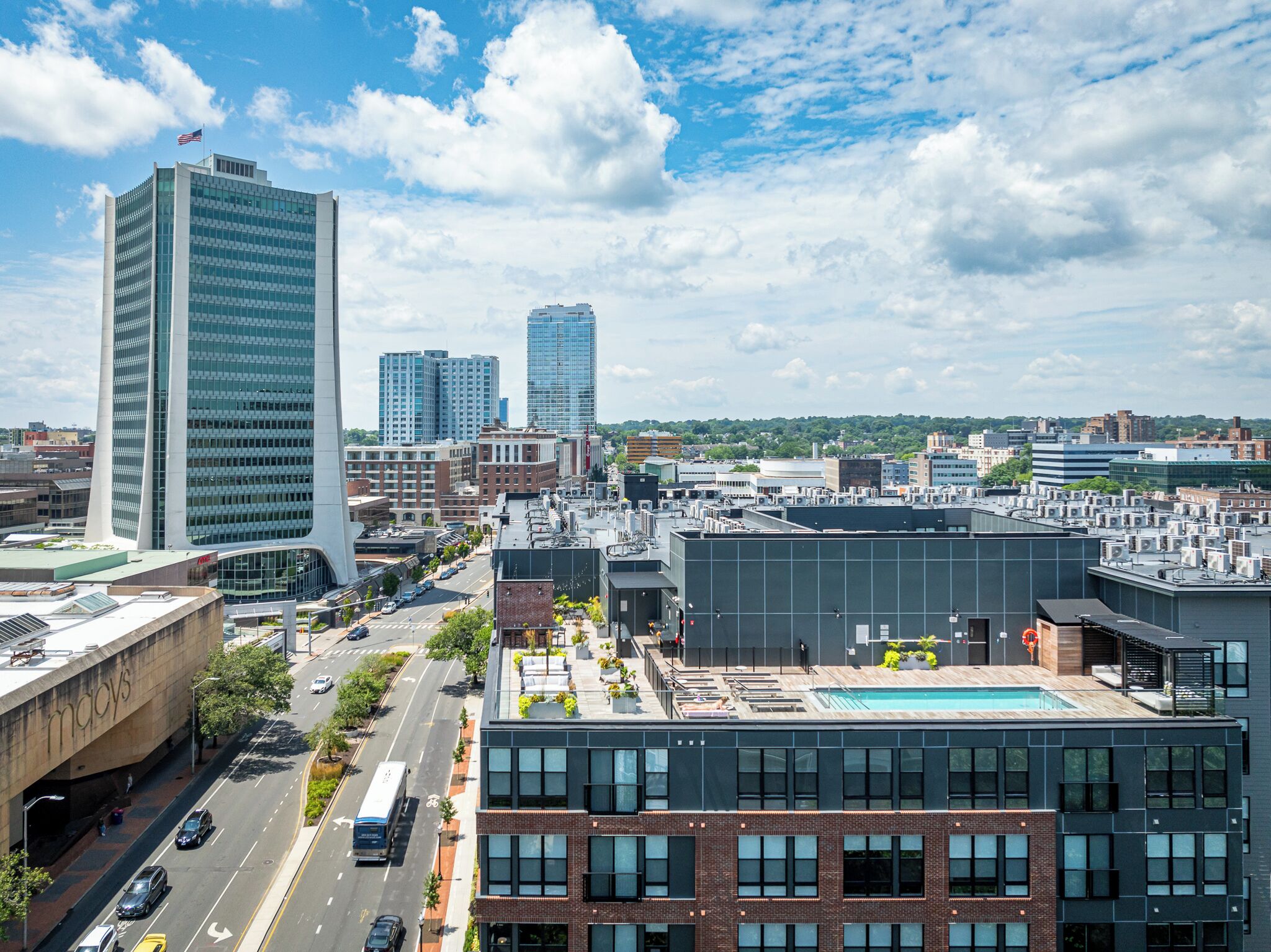 A cityscape with modern buildings, a clear sky, and a view of the street below.