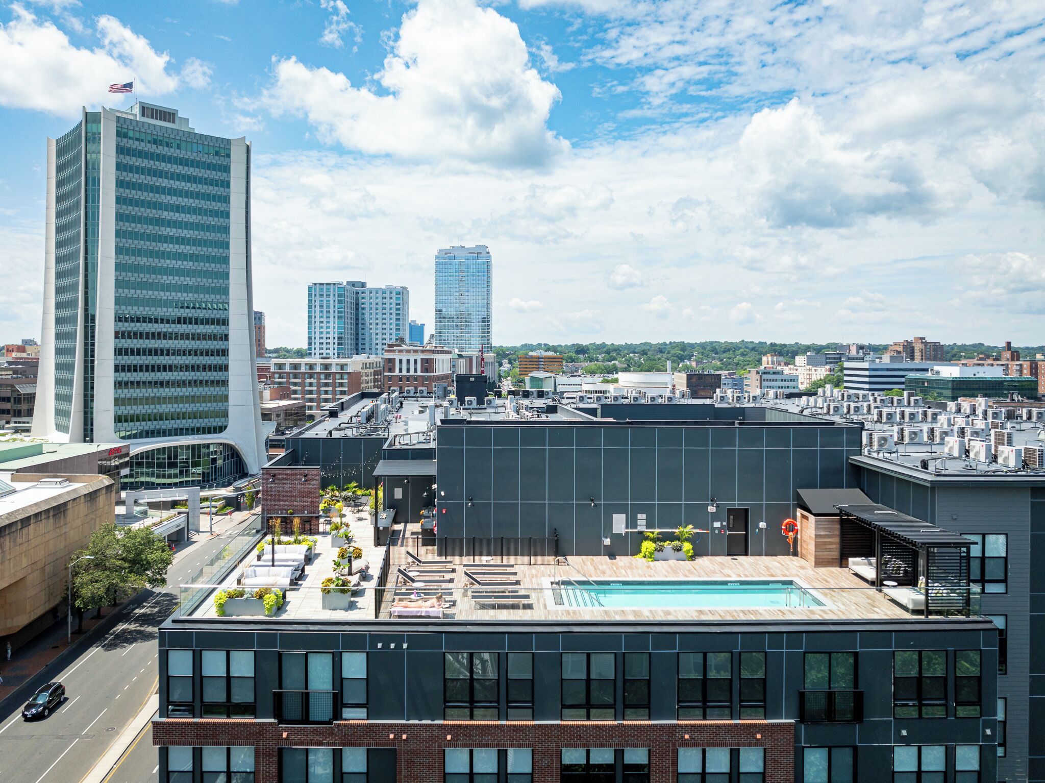 A modern building with a rooftop pool and a view of the city skyline.