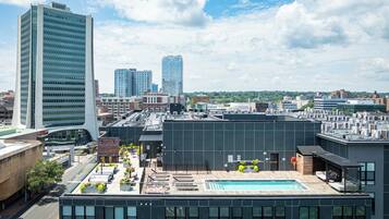 A modern building with a rooftop pool and a view of the city skyline.