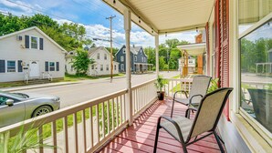 A covered porch with chairs, a view of a street with houses, and a parked car. - < 1 Mi to Historic District! Retreat in Bennington (Bennington)