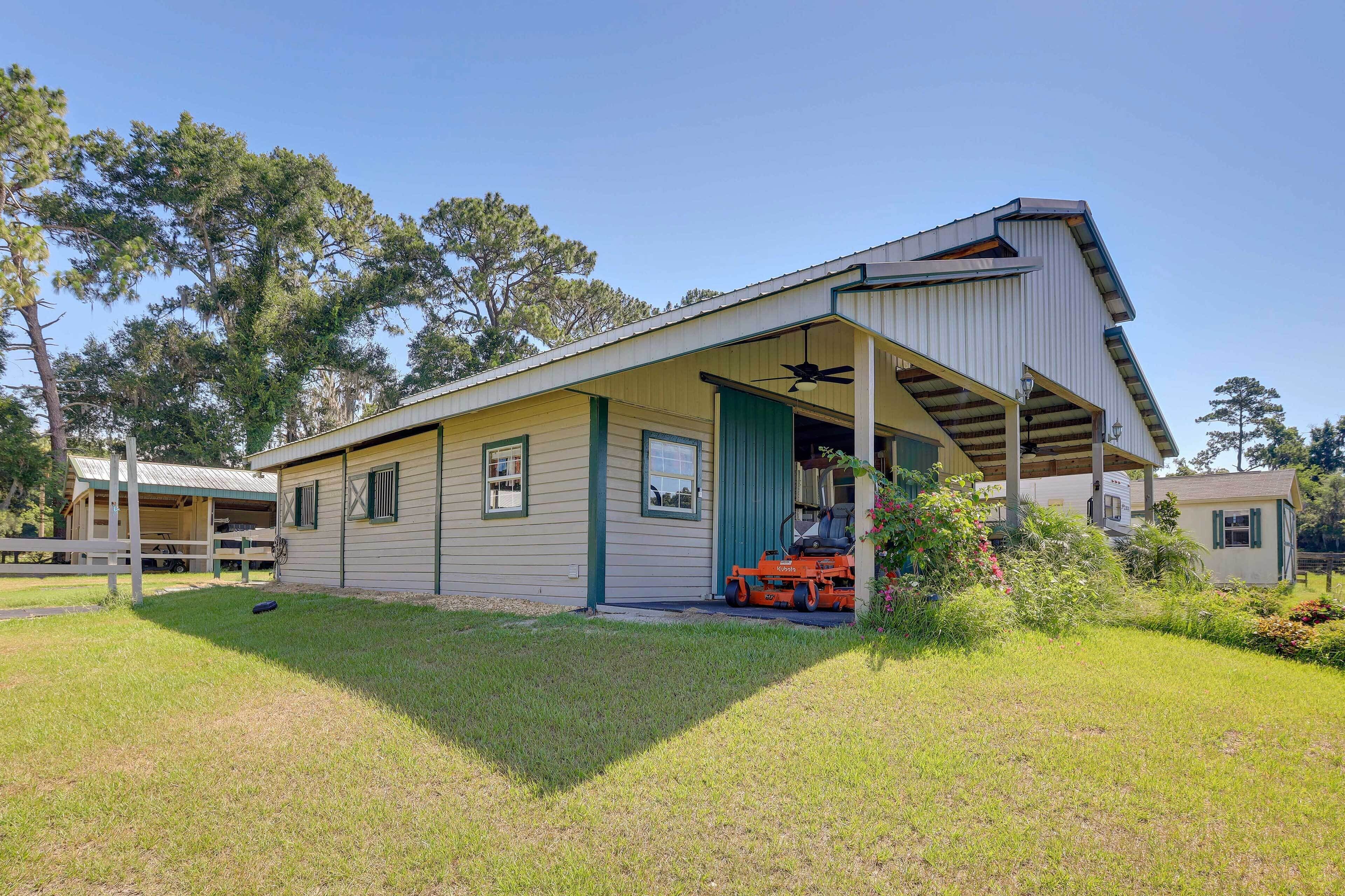 A single-story house with a covered porch, a lawn, and a lawnmower.