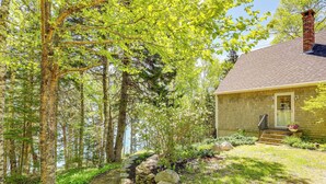 A house with a stone exterior, a brick chimney, and a stone pathway leading to the front door. - Serene Steuben Home w/ Scenic Ocean Views! (Steuben)