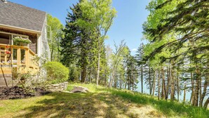 A cabin with a deck overlooking a forest and a lake. - Serene Steuben Home w/ Scenic Ocean Views! (Steuben)