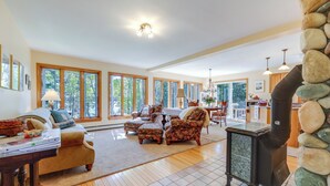 A spacious living room with a fireplace, large windows, and a cozy seating area. - Serene Steuben Home w/ Scenic Ocean Views! (Steuben)