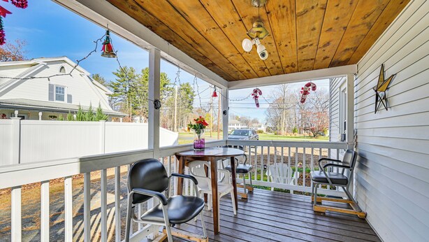 A covered porch with wooden flooring, white railings, and two tables with chairs. - Bring Your Pet & Visit Springfield: Westfield Home (Westfield)