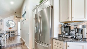 A modern kitchen with stainless steel appliances, a granite countertop, and a dining area with a table and chairs. - Waterfront w/ Boat Dock: Retreat on Indian Lake (Belle Center)