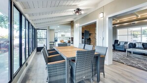 A spacious living area with a large dining table, wicker chairs, and a view through large windows. - 16 Mi to Manatee Viewing! Spacious Tampa Retreat (Tampa)