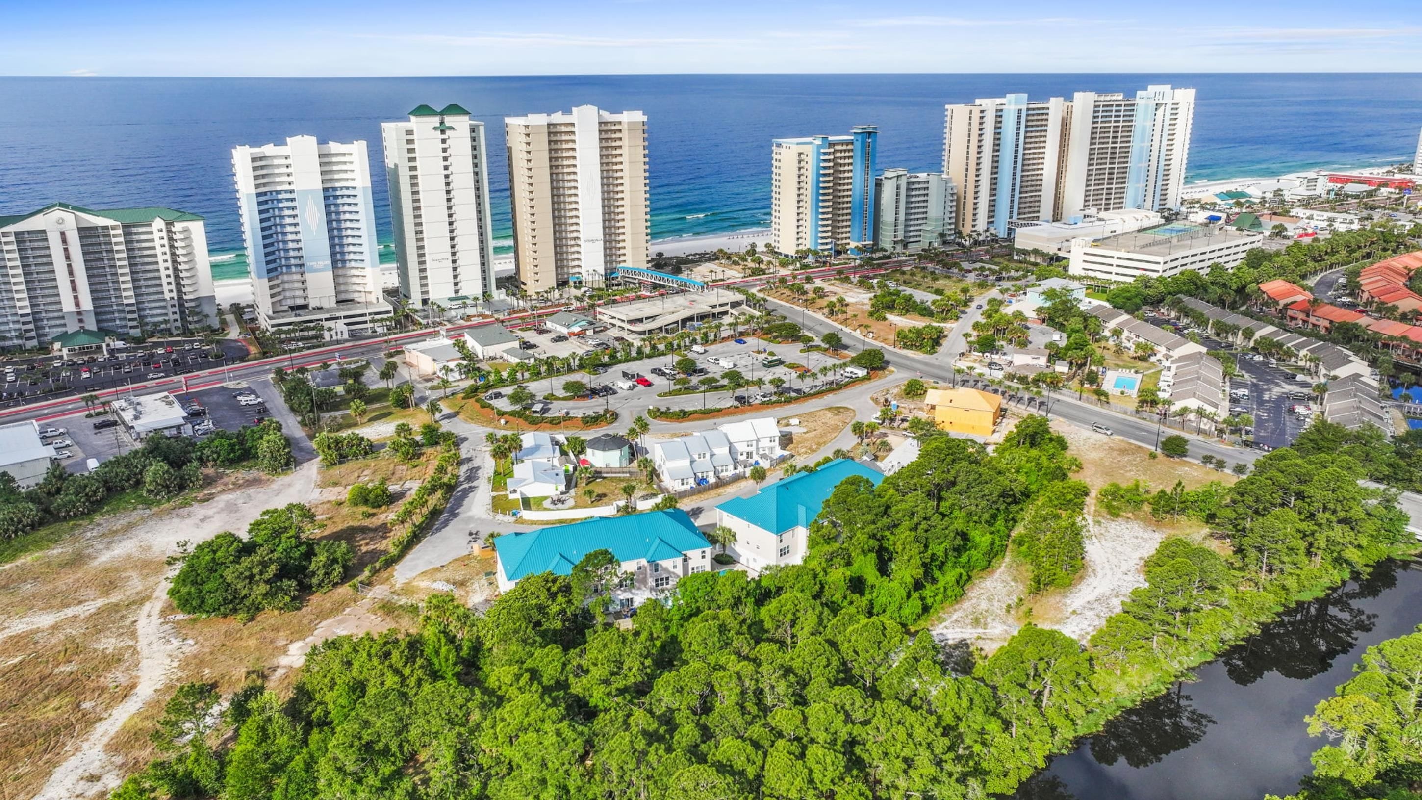 A coastal cityscape with high-rise hotels, a marina, and a golf course.