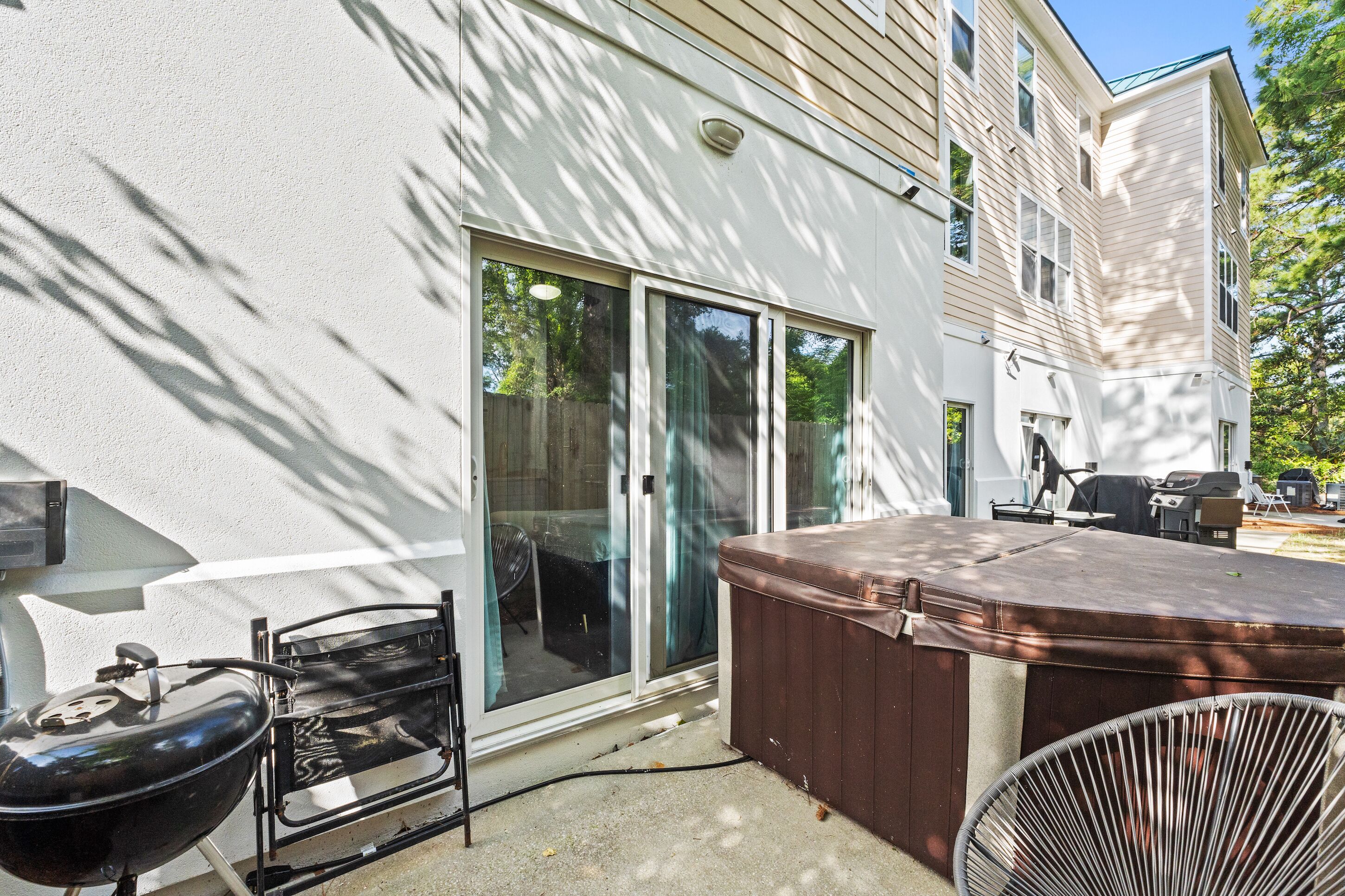 Een terras met een barbecue, een jacuzzi en een stoel.