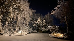 Schneebedeckte Landschaft mit einem gepflasterten Weg und einem Schild mit der Aufschrift 'THE GRAND'.