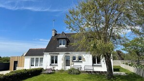 A two-story house with a stone facade, a pitched roof, and a large tree in the front yard. - CAP PLAGE 10 minutes' walk  (AUDIERNE)