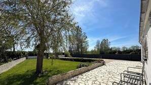 A courtyard with a stone pathway, a tree, and a metal bench. - CAP PLAGE 10 minutes' walk  (AUDIERNE)