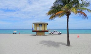 A beach with a lifeguard tower, a palm tree, and a white pickup truck. - 3/2 NEW for 6, Steps to Hollywood Beach-Boardwalk (Hollywood)