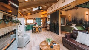 A spacious living area with a fireplace, a dining table, and a cozy seating area. - Autumn Blaze at Maple Treehouse (Wildwood)