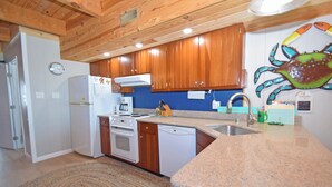 A kitchen with wooden cabinets, a stove, a dishwasher, and a sink. - Sea Edge 3-Oceanfront 36th St, W/D, AC, Free WIFI (Ocean City)
