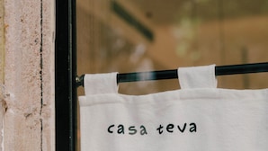 Un paño blanco colgado de una barra de metal negro con la inscripción 'casa teva'.