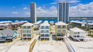 Un hôtel situé en bord de mer, composé de plusieurs bâtiments à étages, avec une plage de sable fin et une vue dégagée sur l’océan.