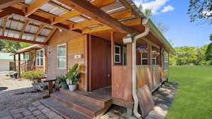 A wooden cabin with a covered porch, steps leading to the entrance, and a small outdoor seating area. - Beautiful Cabin in a great neighborhood and minutes from Baton Rouge!! (Denham Springs)