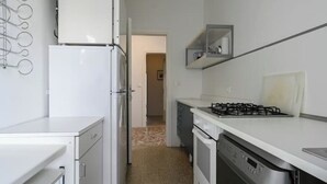 A compact kitchen with a refrigerator, stove, oven, and dishwasher. - VILLA MARGHERITA 1 (Lido di Jesolo)
