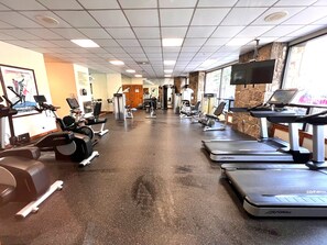 A gym with treadmills, weight machines, and exercise equipment.