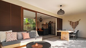 Un espace de vie moderne comprenant un canapé, une table à manger et une cuisine en arrière-plan.