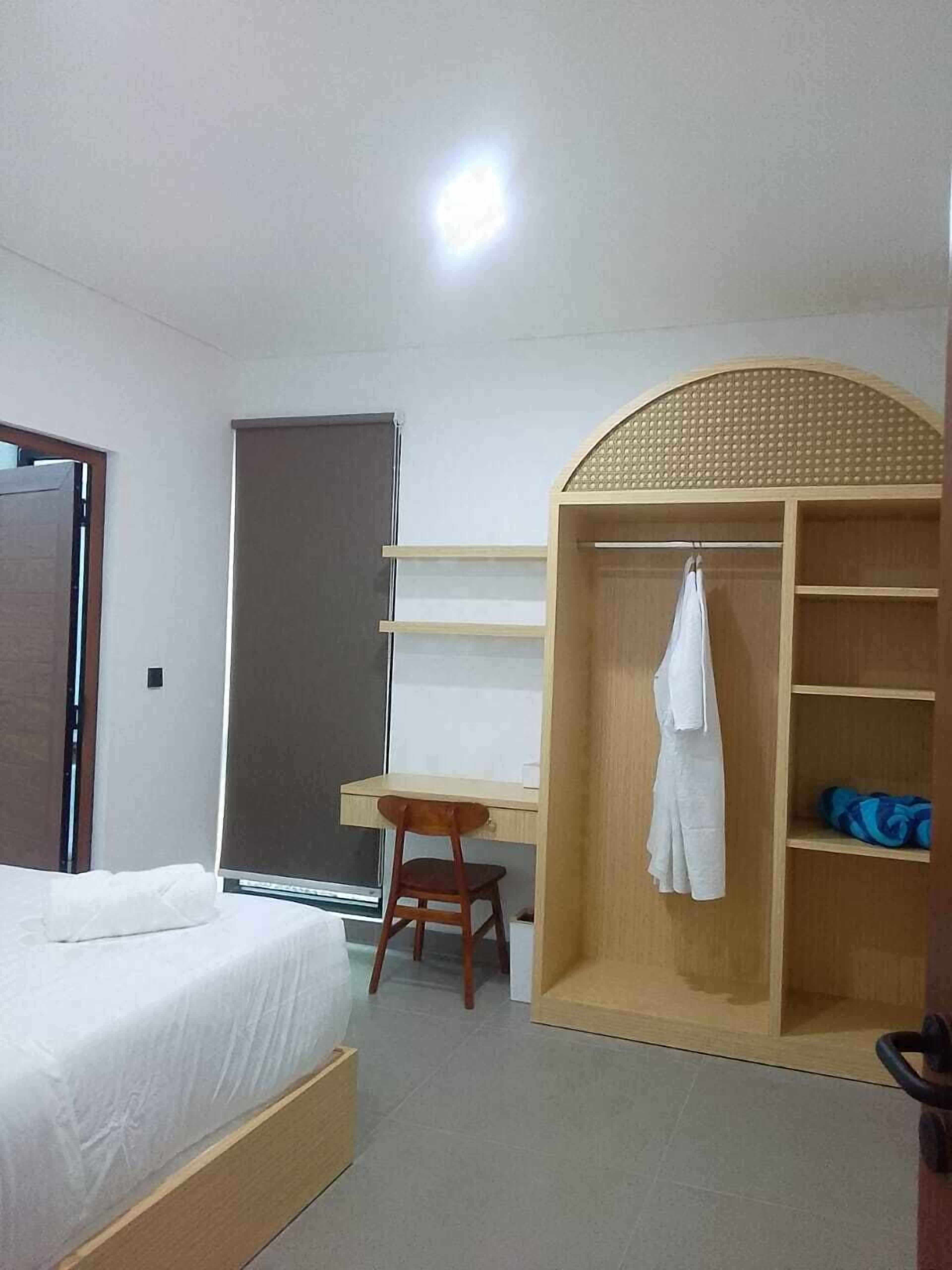 Una camera da letto con un letto, una scrivania e un armadio.