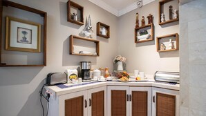 Una cocina con armarios de madera, una encimera con varios electrodomésticos y estantes con adornos.