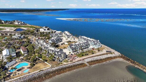 A coastal resort with multiple buildings, a swimming pool, and a rocky shoreline. - Spectacular Ocean Front Bedroom Views - 626 Newhaven (Fripp Island)