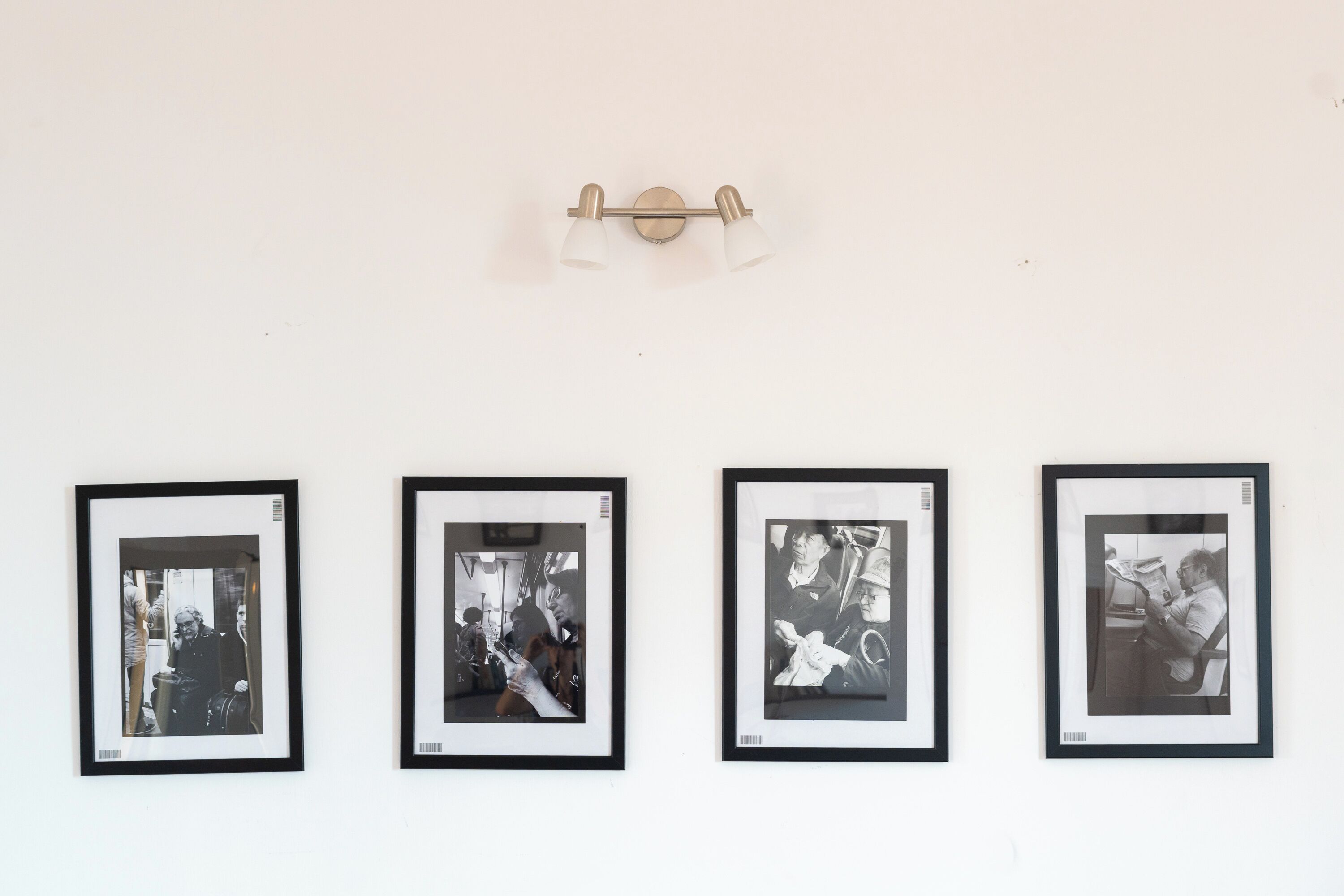 Vier gerahmte Fotografien hängen an einer Wand, jede mit schwarzem Rahmen.