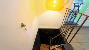 A staircase with a metal handrail and a wall-mounted light fixture. - Panoramic Penthouse in Naples by Wonderful Italy (Naples)