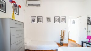 A bedroom with a bed, a dresser, a nightstand, a lamp, and framed pictures on the wall. - Panoramic Penthouse in Naples by Wonderful Italy (Naples)