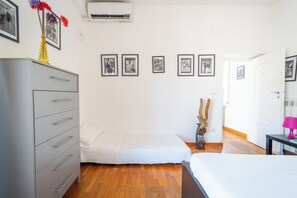 A bedroom with a bed, a dresser, a nightstand, a lamp, and framed pictures on the wall. - Panoramic Penthouse in Naples by Wonderful Italy (Naples)