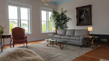 Relax in a stylish living room with a plush armchair, comfortable sofa, and a glass coffee table.