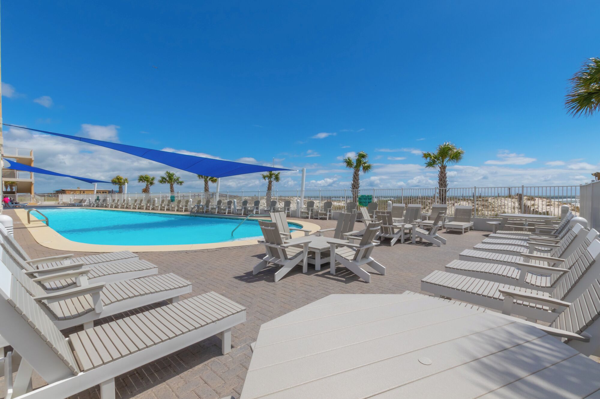 A rooftop pool area with lounge chairs and a swimming pool.