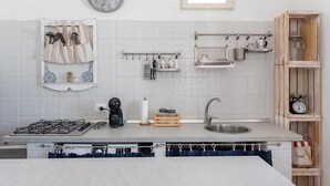 A modern kitchen with a gas stove, sink, and various utensils and appliances. - Villetta Emanuela by Wonderful Italy (Syracuse)