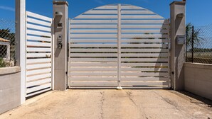 A gated entrance with a number 44 sign, a security keypad, and a metal gate. - Villetta Emanuela by Wonderful Italy (Syracuse)