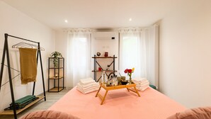 Una habitación ordenada con una cama, una estantería con plantas y un tendedero.