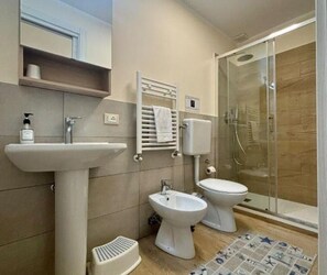 Een douche, een haardroger, een bidet, handdoeken