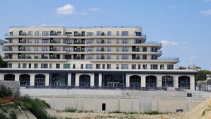 Un immeuble à plusieurs étages, doté de balcons, de grandes fenêtres et d’un toit plat.