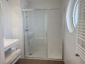 Chuveiro, secador de cabelo, toalhas de banho, papel higiênico