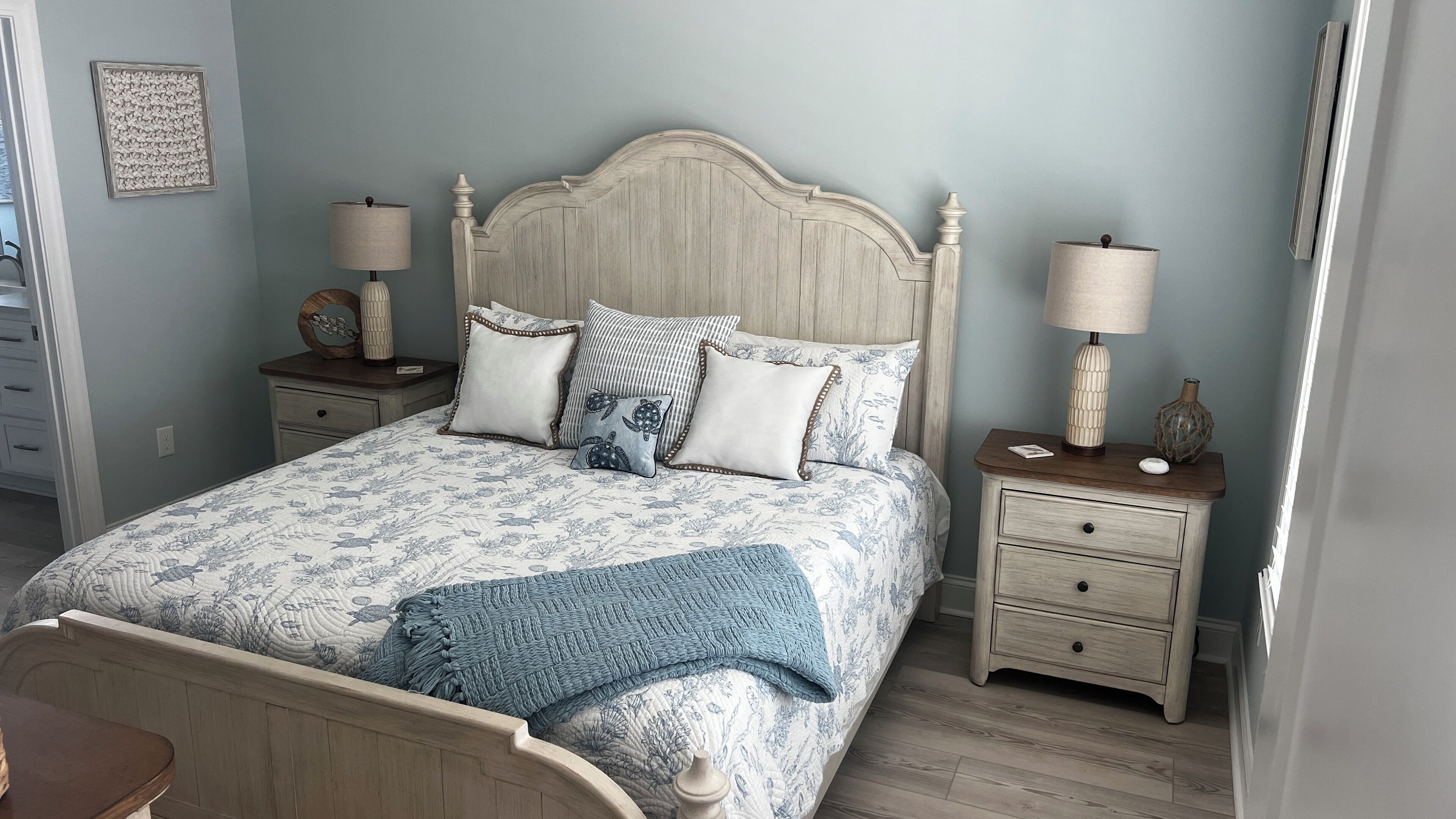 Een slaapkamer met een houten bed, twee nachtkastjes en een bedbank.