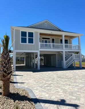 A two-story house with a balcony and a covered porch area.